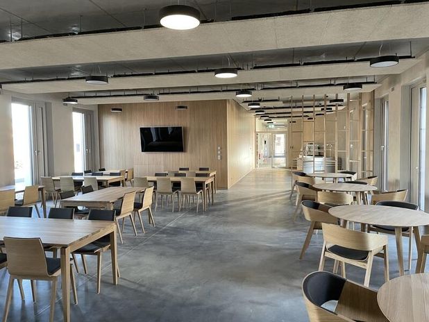 Stadtwerke - Neubau Haus 2 in der Innenansicht mit Tischen und Stühlen